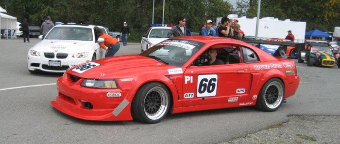Tim Brown driving his /66 red Ford Mustang race car