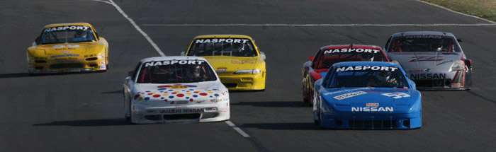 five race cars bunched close together going down a straight away